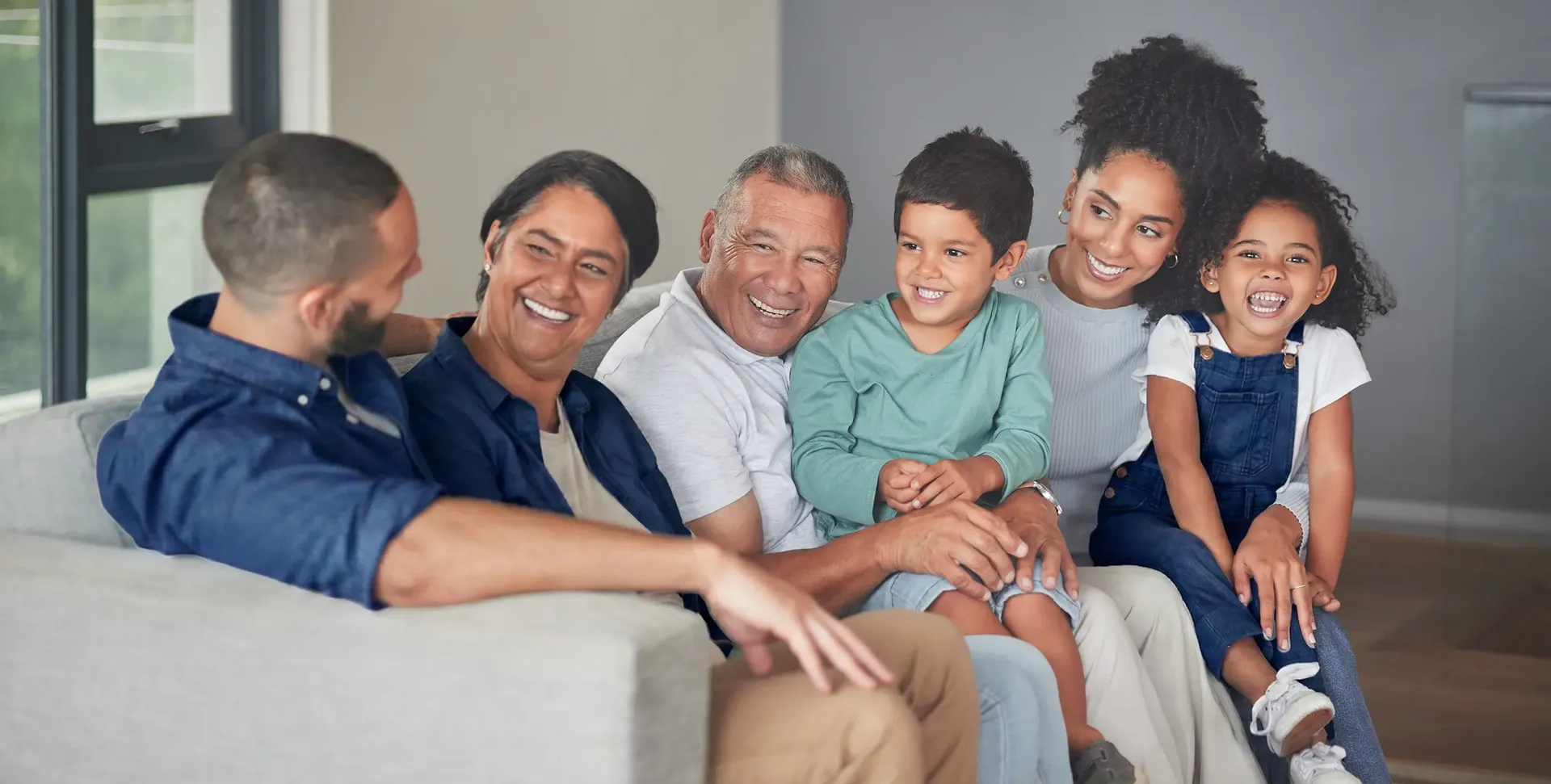 Multigenerational family smiling together on couch